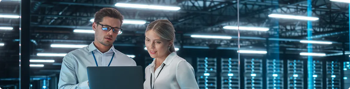 Chief engineer talks with an electronics specialist while working on a laptop